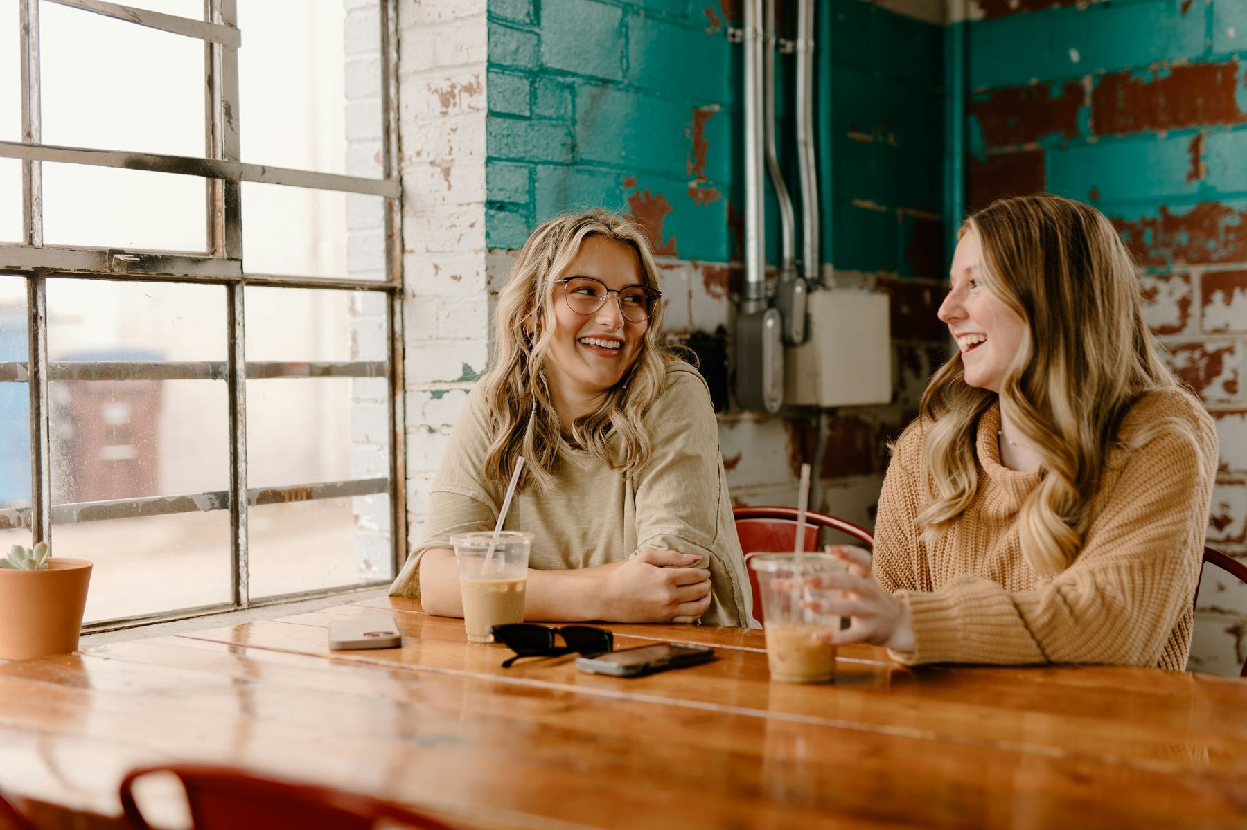 Two people talking over coffee at a bright table